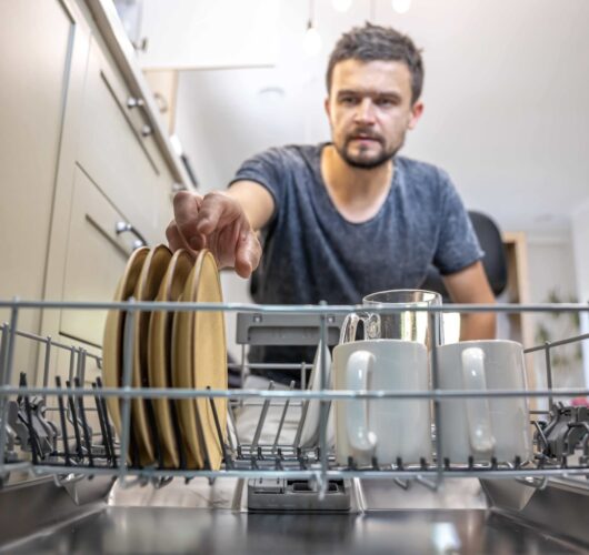 man-front-open-dishwasher-takes-out-puts-down-dishes (1)-min (1)