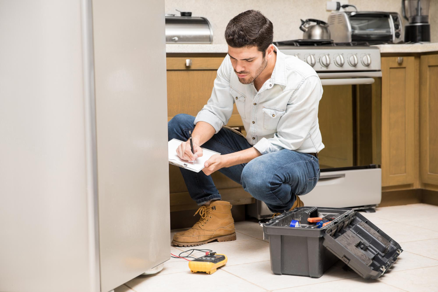 Ideal Refrigeration technician repairing a domestic fridge in Wynnum, Brisbane Bayside